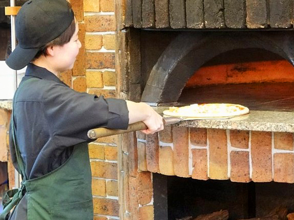 佐久平ハイウェイオアシスピザ専門店「Pizza Time」ピザ窯でピザを焼くスタッフ