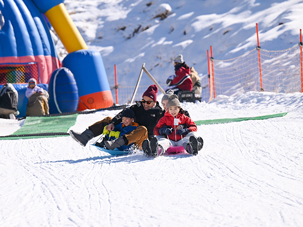 佐久スキーガーデンパラダ「キッズランド」でソリを滑る親子