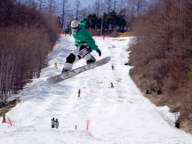 八千穂高原スキー場で滑走するスノーボーダー