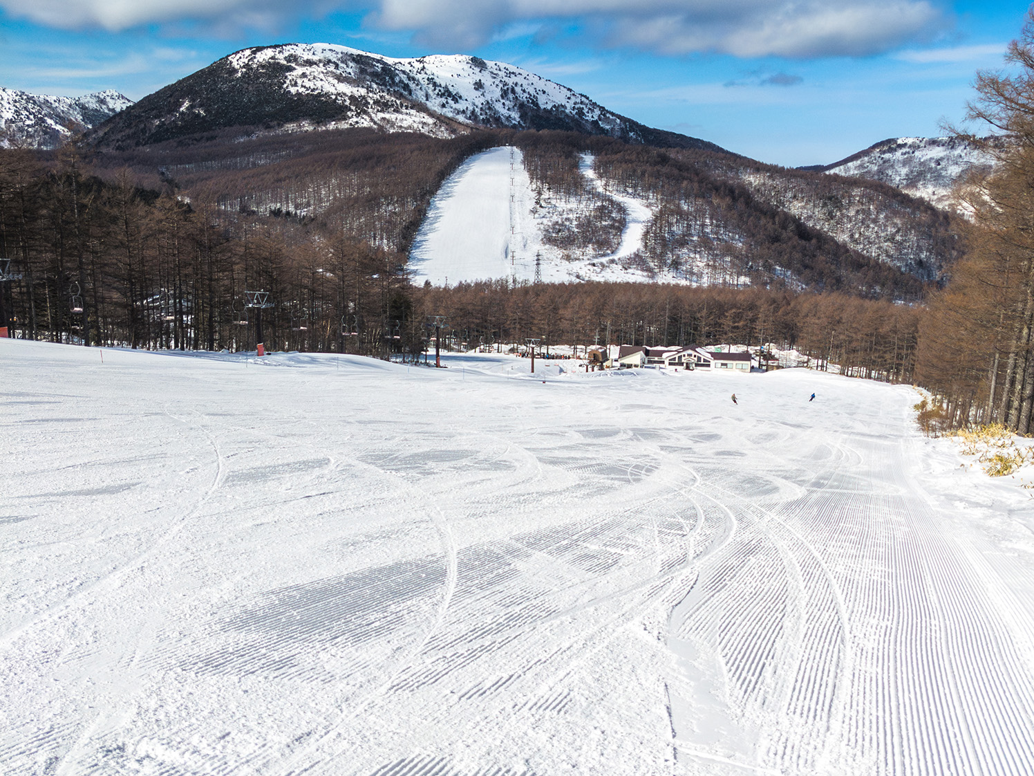 滑走跡と圧雪模様が残る冬のゲレンデと湯ノ丸山の景色 湯の丸高原