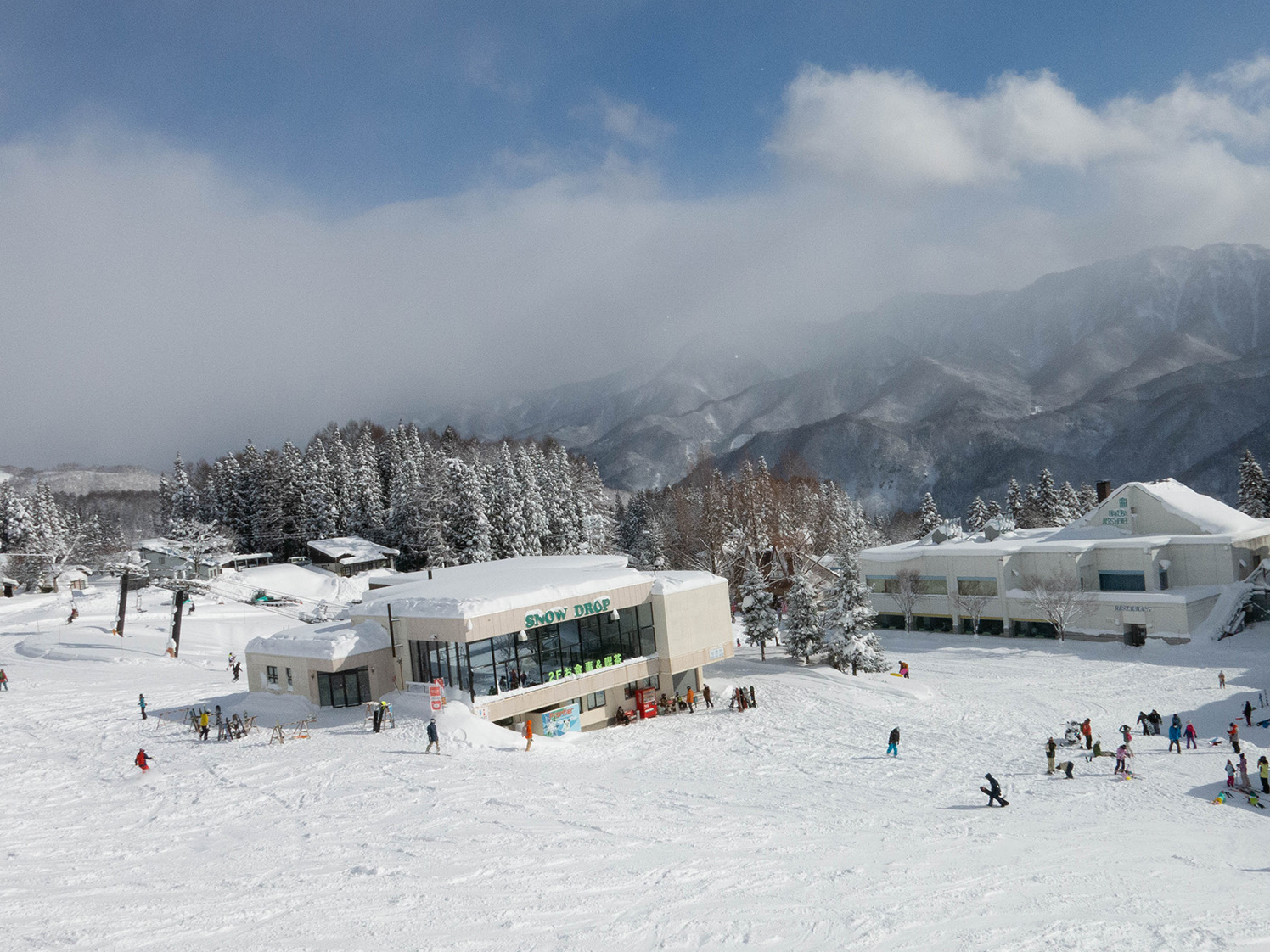 白馬乗鞍温泉スキー場でソリを楽しむ親子