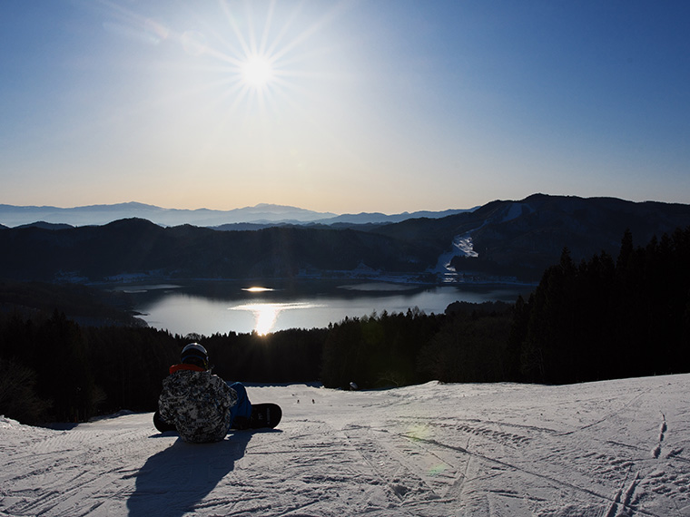 白馬さのさかスキー場　サンライズ営業で朝日を浴びて滑走準備をするスノーボーダー