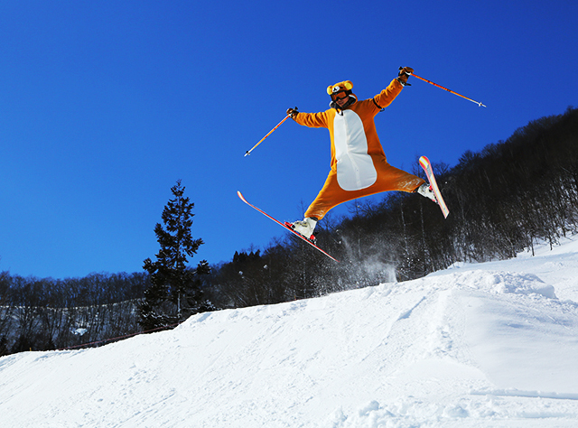 白馬さのさかスキー場の人工コブを備えたモーグルコースで滑走するスキーヤー