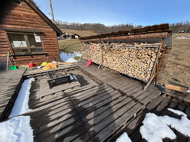 爺が岳スキー場中腹の昼のログハウス横のウッドデッキと焚き火台