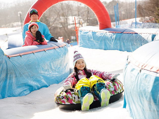 スノーマンパークのチュービングで滑る子ども