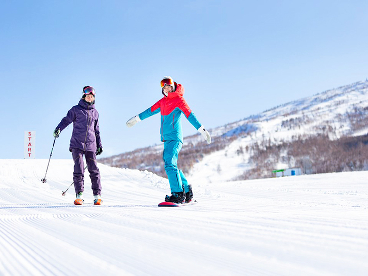 菅平高原スノーリゾートのリフトとスノーボードを楽しむ人
